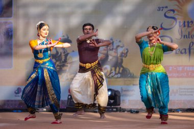 Faridabad, Haryana, Hindistan - 17 Şubat 2024: Etnik sanatlar fuarı sırasında erkek ve kadın Hintli sanatçılar sahnede klasik dans kuchipudi performansı sergiliyorlar. 
