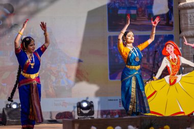 Faridabad, Haryana, Hindistan - 17 Şubat 2024: Güney Hintli kadın sanatçılar geleneksel ipek sariler ve mücevherlerle Surajkund zanaat fuarında klasik dans kuchipudi performansı sergiliyorlar. 