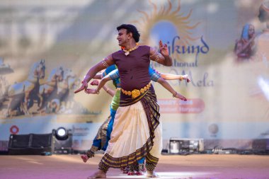 Faridabad, Haryana, Hindistan - 17 Şubat 2024: Etnik sanatlar fuarı sırasında erkek ve kadın Hintli sanatçılar sahnede klasik dans kuchipudi performansı sergiliyorlar. 