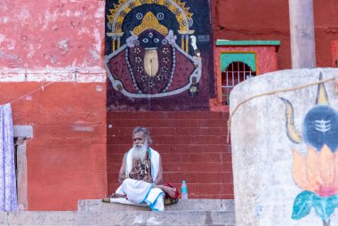 Varanasi, Uttar Pradesh, Hindistan - 05 Mart 2023: Varanasi 'deki çetelerin yakınındaki ghatlarda geleneksel giysiler giyen insanlar.