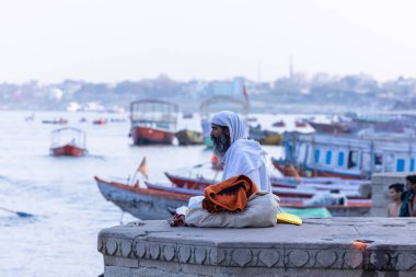 Varanasi, Uttar Pradesh, Hindistan - 05 Mart 2023: Varanasi 'deki çetelerin yakınındaki ghatlarda geleneksel giysiler giyen insanlar.