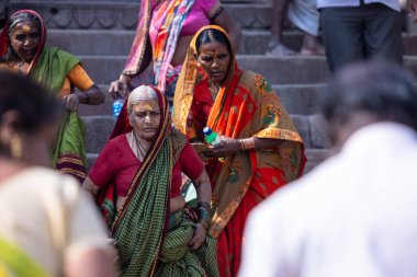 Varanasi, Uttar Pradesh, Hindistan - 05 Mart 2023: Varanasi 'deki çetelerin yakınındaki ghatlarda geleneksel giysiler giyen insanlar.