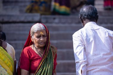 Varanasi, Uttar Pradesh, Hindistan - 05 Mart 2023: Varanasi 'deki çetelerin yakınındaki ghatlarda geleneksel giysiler giyen insanlar.