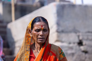 Varanasi, Uttar Pradesh, Hindistan - 05 Mart 2023: Varanasi 'deki çetelerin yakınındaki ghatlarda geleneksel giysiler giyen insanlar.