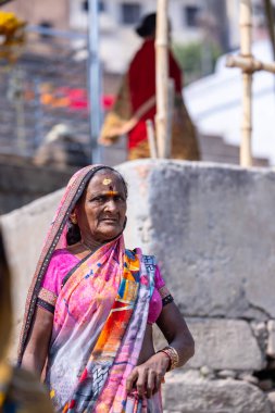 Varanasi, Uttar Pradesh, Hindistan - 05 Mart 2023: Varanasi 'deki çetelerin yakınındaki ghatlarda geleneksel giysiler giyen insanlar.