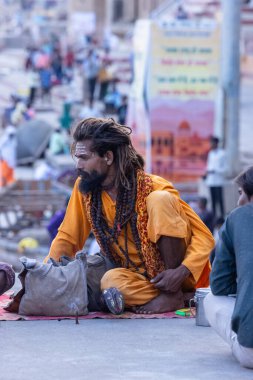 Varanasi, Uttar Pradesh, Hindistan - 05 Mart 2023: Varanasi 'deki çetelerin yakınındaki ghatlarda geleneksel giysiler giyen insanlar.