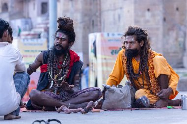 Varanasi, Uttar Pradesh, Hindistan - 05 Mart 2023: Varanasi 'deki çetelerin yakınındaki ghatlarda geleneksel giysiler giyen insanlar.