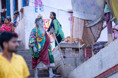Varanasi, Uttar Pradesh, Hindistan - 05 Mart 2023: Varanasi 'deki çetelerin yakınındaki ghatlarda geleneksel giysiler giyen insanlar.