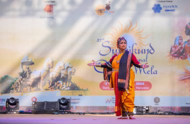 Faridabad, Haryana, Hindistan - 17 Şubat 2024: Güney Hintli kadın sanatçının portresi geleneksel ipek sari ve mücevherlerle Surajkund zanaat fuarında klasik dans kuchipudi gösterisi yapıyor.