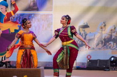 Faridabad, Haryana, Hindistan - 17 Şubat 2024: Güney Hintli kadın sanatçıların portresi geleneksel ipek sari ve mücevherlerle Surajkund zanaat fuarında klasik dans kuchipudi gösterisi yapıyor.