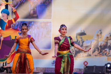 Faridabad, Haryana, Hindistan - 17 Şubat 2024: Güney Hintli kadın sanatçıların portresi geleneksel ipek sari ve mücevherlerle Surajkund zanaat fuarında klasik dans kuchipudi gösterisi yapıyor.