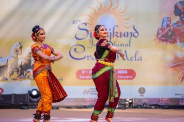 Faridabad, Haryana, Hindistan - 17 Şubat 2024: Güney Hintli kadın sanatçıların portresi geleneksel ipek sari ve mücevherlerle Surajkund zanaat fuarında klasik dans kuchipudi gösterisi yapıyor.