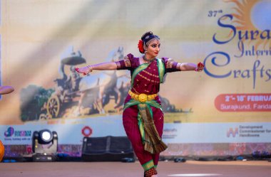 Faridabad, Haryana, Hindistan - 17 Şubat 2024: Güney Hintli kadın sanatçının portresi geleneksel ipek sari ve mücevherlerle Surajkund zanaat fuarında klasik dans kuchipudi gösterisi yapıyor.