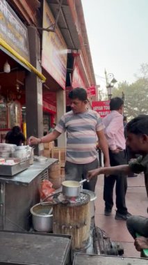 Varanasi, Uttar Pradesh, Hindistan - 24 Mart 2023: Sokak çayhanesi, Varanasi 'deki Dashashwamedh ghat' ta nehir çeteleri yakınında çay hazırlayan bir çay satıcısının portresi.