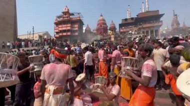 Varanasi, Uttar Pradesh, Hindistan - 24 Mart 2023: Masan Holi, genç erkek ressamlar grubu Manabazka ghat 'ta güneş bayramını kutlamak için küle boyanmış yüzlerle damru oynuyorlar..