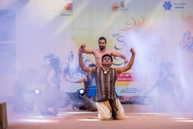 Faridabad, Haryana, Hindistan - 17 Şubat 2024: Güney Hintli erkek sanatçıların portresi Surajkund sanat fuarı sırasında sahnede klasik dans kuchipudi performansı sergiliyor.