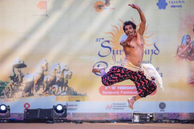 Faridabad, Haryana, Hindistan - 17 Şubat 2024: Güney Hintli erkek sanatçı surajkund sanatları fuarı sırasında sahnede klasik dans kuchipudi performansı sergiliyor.