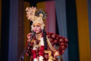 Gaziabad, Uttar Pradesh, Hindistan - 17 Mart 2024: Renkli etnik kıyafetlerle Holi Festivali sırasında Phoolo ki holi 'yi Lord Krishna olarak oynayan erkek sanatçının portresi.