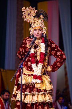 Gaziabad, Uttar Pradesh, Hindistan - 17 Mart 2024: Renkli etnik kıyafetlerle Holi Festivali sırasında Phoolo ki holi 'yi Lord Krishna olarak oynayan erkek sanatçının portresi.