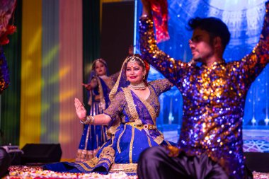 Gaziabad, Uttar Pradesh, Hindistan - 17 Mart 2024: Ghaziabad 'da düzenlenen Holi Festivali sırasında sahnede renkli etnik giysiler içindeki Hintli sanatçıların portresi.
