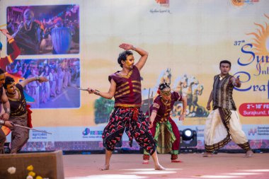 Faridabad, Haryana, Hindistan - 17 Şubat 2024: Surajkund el sanatları fuarı sırasında sahnede klasik dans Kuchipudi performansı sergileyen Güney Hintli sanatçıların portresi.