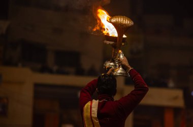 Varanasi, Uttar Pradesh, Hindistan - 18 Ocak 2024: Ganga aarti, Dashashwamedh Ghat geleneksel elbise ve Hindu ayinleri ile Ganj nehri akşam ayini yapan genç rahip portresi.