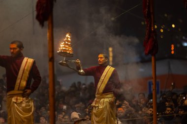 Varanasi, Uttar Pradesh, Hindistan - 18 Ocak 2024: Ganga aarti, Dashashwamedh Ghat geleneksel elbise ve Hindu ayinleri ile Ganj nehri akşam ayini yapan genç rahip portresi.