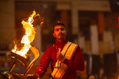 Varanasi, Uttar Pradesh, Hindistan - 18 Ocak 2024: Ganga aarti, Dashashwamedh Ghat geleneksel elbise ve Hindu ayinleri ile Ganj nehri akşam ayini yapan genç rahip portresi.