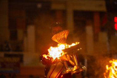 Varanasi, Uttar Pradesh, Hindistan - 18 Ocak 2024: Ganga aarti, Dashashwamedh Ghat geleneksel elbise ve Hindu ayinleri ile Ganj nehri akşam ayini yapan genç rahip portresi.
