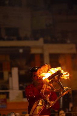 Varanasi, Uttar Pradesh, Hindistan - 18 Ocak 2024: Ganga aarti, Dashashwamedh Ghat geleneksel elbise ve Hindu ayinleri ile Ganj nehri akşam ayini yapan genç rahip portresi.