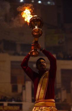 Varanasi, Uttar Pradesh, Hindistan - 18 Ocak 2024: Ganga aarti, Dashashwamedh Ghat geleneksel elbise ve Hindu ayinleri ile Ganj nehri akşam ayini yapan genç rahip portresi.