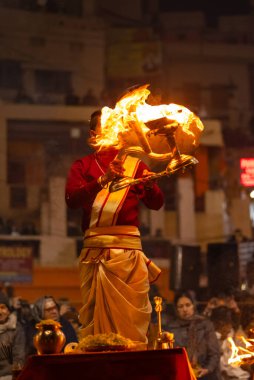 Varanasi, Uttar Pradesh, Hindistan - 18 Ocak 2024: Ganga aarti, Dashashwamedh Ghat geleneksel elbise ve Hindu ayinleri ile Ganj nehri akşam ayini yapan genç rahip portresi.