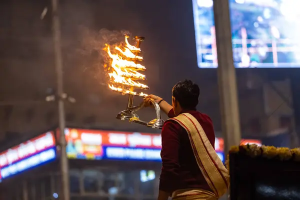 stock image Varanasi, Uttar Pradesh, India - January 18, 2024: Ganga aarti, Portrait of young male priest performing holy river Ganges evening aarti at Dashashwamedh Ghat in traditional dress with hindu rituals.