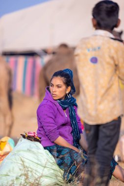 Puşkar, Rajasthan, Hindistan - 24 Kasım 2023: Pushkar Deve Fuarı sırasındaki genç Hintli Rajasthani kadın portresi.