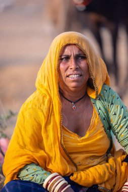 Puşkar, Rajasthan, Hindistan - 24 Kasım 2023: Pushkar Deve Fuarı sırasında, geleneksel renkli elbiseli Hintli kadının portresi.