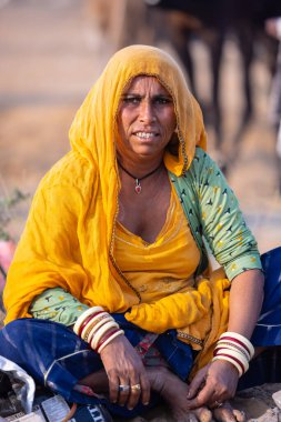 Puşkar, Rajasthan, Hindistan - 24 Kasım 2023: Pushkar Deve Fuarı sırasında, geleneksel renkli elbiseli Hintli kadının portresi.