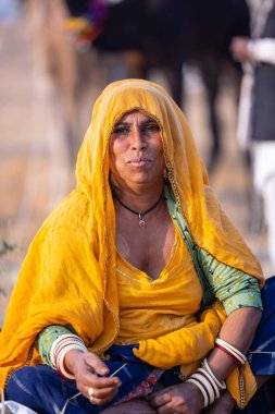 Puşkar, Rajasthan, Hindistan - 24 Kasım 2023: Pushkar Deve Fuarı sırasında, geleneksel renkli elbiseli Hintli kadının portresi.