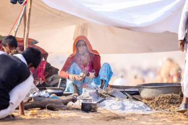 Puşkar, Rajasthan, Hindistan - 24 Kasım 2023: Pushkar Deve Fuarı sırasında, geleneksel renkli elbiseli Hintli kadının portresi.