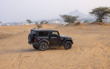 Pushkar, Rajasthan, India - November 25 2023: An 4*4 gypsy riding on the Thar desert of Pushkar for adventure car rally.  clipart