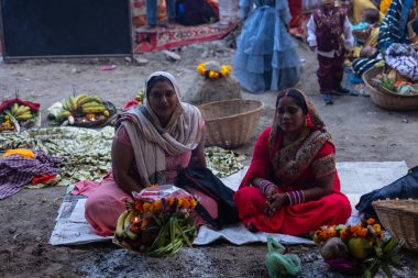 Ghaziabad, Uttar Pradesh, India - November 19, 2023: Chhath Puja, Group of indian women sitting on ground to perform the rituals of Chhath puja in traditional ethnic clothes. clipart