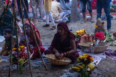 Gaziabad, Uttar Pradesh, Hindistan - 19 Kasım 2023: Chhas Puja, bir grup Hintli kadın geleneksel etnik kıyafetlerle Chhas puja ayinlerini gerçekleştirmek için yerlerinde oturuyorlar.