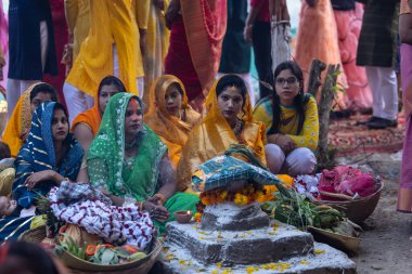 Gaziabad, Uttar Pradesh, Hindistan - 19 Kasım 2023: Chhas Puja, bir grup Hintli kadın geleneksel etnik kıyafetlerle Chhas puja ayinlerini gerçekleştirmek için yerlerinde oturuyorlar.