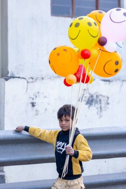 Gaziabad, Uttar Pradesh, Hindistan - 19 Kasım 2023: Chhas puja sırasında balon taşıyan bir çocuğun portresi.