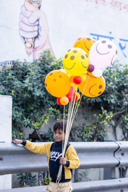 Gaziabad, Uttar Pradesh, Hindistan - 19 Kasım 2023: Chhas puja sırasında balon taşıyan bir çocuğun portresi.