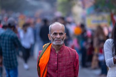 Gaziabad, Uttar Pradesh, Hindistan - 19 Kasım 2023: Nehir kıyısına doğru yürüyen bir grup Hintli aile ile birlikte etnik renkli giysiler içinde Chhas puja ayinlerini gerçekleştirmek için.