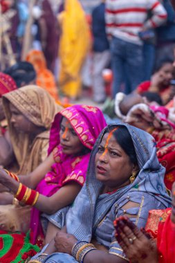 Gaziabad, Uttar Pradesh, Hindistan - 19 Kasım 2023: Chhas Puja, bir grup Hintli kadın geleneksel etnik kıyafetlerle Chhas puja ayinlerini gerçekleştirmek için yerlerinde oturuyorlar.