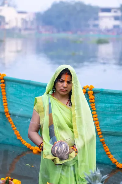 stock image Ghaziabad, Uttar Pradesh, India - November 19 2023: Chhath Puja, Portrait of indian hindu female devotee performing rituals of chhath puja with standing in river to worship lord sun during sunset.