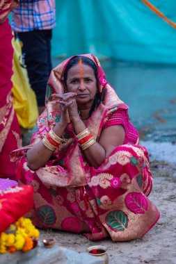 Gaziabad, Uttar Pradesh, Hindistan - 19 Kasım 2023: Chhas Puja, bir grup Hintli kadın geleneksel etnik kıyafetlerle chhas puja ayinlerini gerçekleştirmek için zemin üzerinde oturuyorlar.
