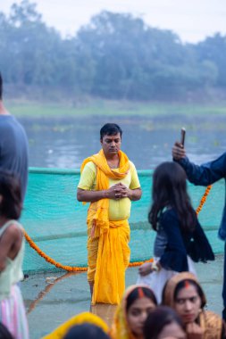 Gaziabad, Uttar Pradesh, Hindistan - 19 Kasım 2023: Chhas Puja, Hintli Hintli erkek dindar portresi Chhas puja ritüellerini gerçekleştiriyor ve gün batımında Lord Sun 'a ibadet etmek için nehirde duruyor..