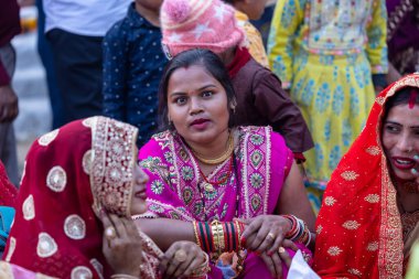 Gaziabad, Uttar Pradesh, Hindistan - 19 Kasım 2023: Chhas Puja, bir grup Hintli kadın geleneksel etnik kıyafetlerle Chhas puja ayinlerini gerçekleştirmek için yerlerinde oturuyorlar.